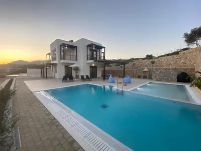 a villa with a swimming pool in front of a house at Pefkos Vista Luxury Villas in Pefki Rhodes