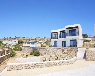 a house with a bunch of animals sitting in front of it at Pefkos Vista Luxury Villas in Pefki Rhodes
