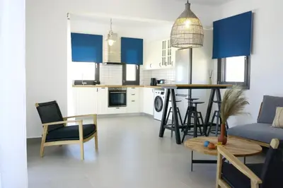 a kitchen and living room with blue cabinets and a table at Pefkos Vista Luxury Villas in Pefki Rhodes