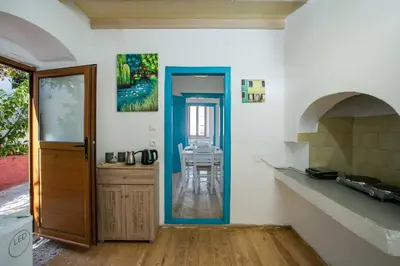 a kitchen with a door and a table in a room at Galini & Serena Apartments in Symi