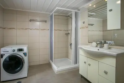 a bathroom with a washing machine and a sink at Galini & Serena Apartments in Symi
