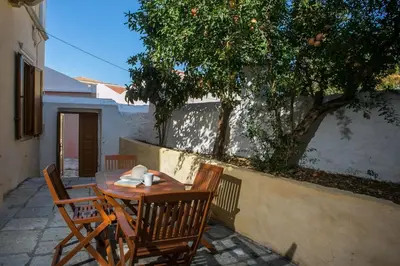 a wooden table and chairs on a patio at Galini & Serena Apartments in Symi
