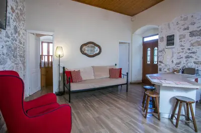 a living room with a couch and a red chair at Galini & Serena Apartments in Symi