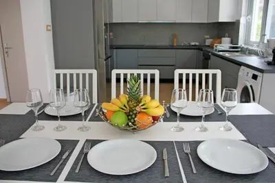 a table with plates and wine glasses and a bowl of fruit at Villa Dana in Ixia
