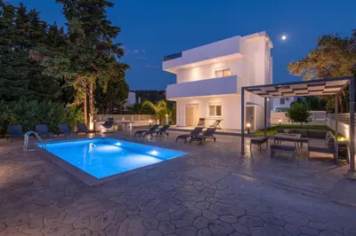 a villa with a swimming pool in front of a house at Villa Dana in Ixia
