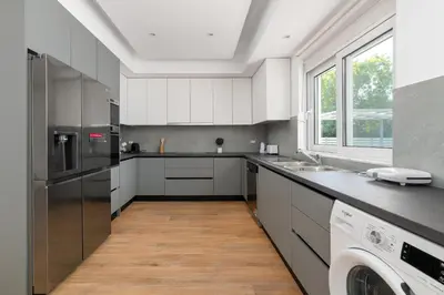 a kitchen with white cabinets and a washer and dryer at Villa Dana in Ixia