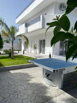 a ping pong table in front of a house at Villa Dana in Ixia