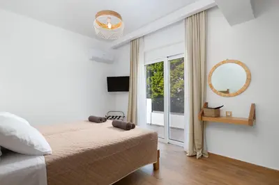 a white bedroom with a bed and a window at Villa Dana in Ixia