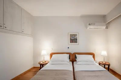 two beds in a room with two lamps at Plumeria Alba Apartment in Rhodes Town