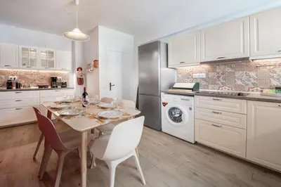 a kitchen with a table and chairs in a kitchen at Plumeria Alba Apartment in Rhodes Town