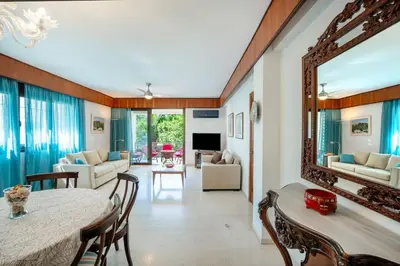 a living room with a table and a mirror at Plumeria Alba Apartment in Rhodes Town