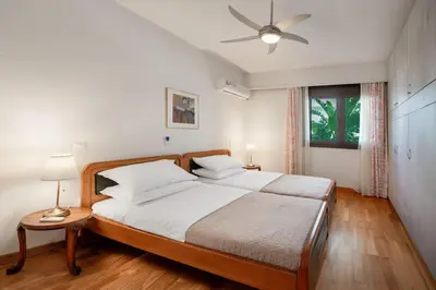 a bedroom with a bed and a ceiling fan at Plumeria Alba Apartment in Rhodes Town