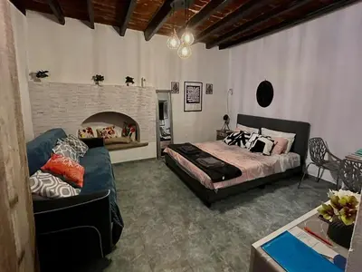a bedroom with a bed and a couch and a fireplace at Symi Blue Studio in Symi