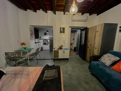 a living room with a blue couch and a kitchen at Symi Blue Studio in Symi