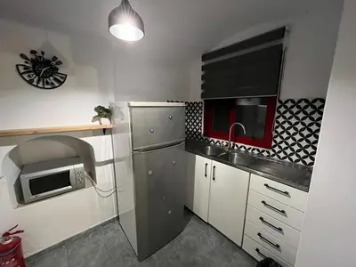 a small kitchen with a refrigerator and a microwave at Symi Blue Studio in Symi