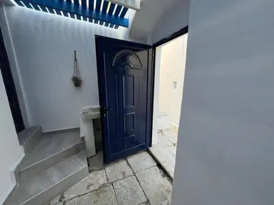 a blue door on a white wall with a staircase at Symi Blue Studio in Symi
