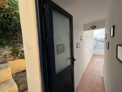 a black door with a glass window in a hallway at Symi Blue Studio in Symi