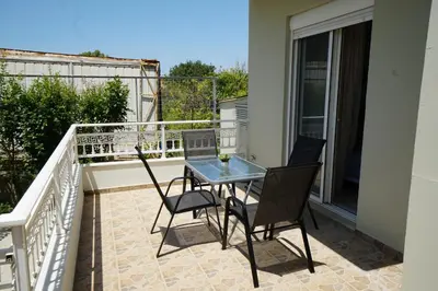 a patio with a table and chairs on a balcony at Anna's Apartments in Kremasti