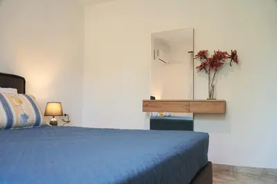 a bedroom with a blue bed and a mirror at Anna's Apartments in Kremasti