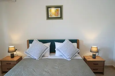 a bedroom with a bed with two night stands and two lamps at Anna's Apartments in Kremasti