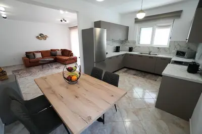 a kitchen with a wooden table with a bowl of fruit on it at Anna's Apartments in Kremasti