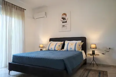 a bedroom with a bed with blue sheets and pillows at Anna's Apartments in Kremasti