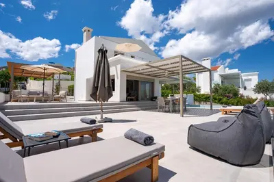 a villa with a swimming pool and a house at Nostos Villa in Kalathos