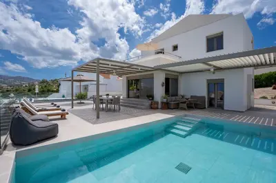 a villa with a swimming pool and a house at Nostos Villa in Kalathos