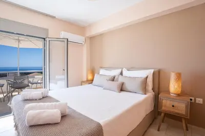 a bedroom with a bed with a view of the ocean at Nostos Villa in Kalathos