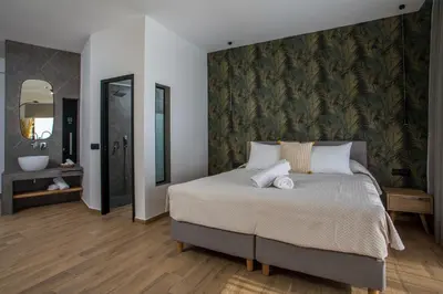 a bedroom with a large bed and a bathroom at 3K Rodo Rooms in Faliraki