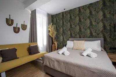 a bedroom with a bed and a yellow couch at 3K Rodo Rooms in Faliraki