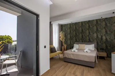 a bedroom with a bed and a table with a chair at 3K Rodo Rooms in Faliraki