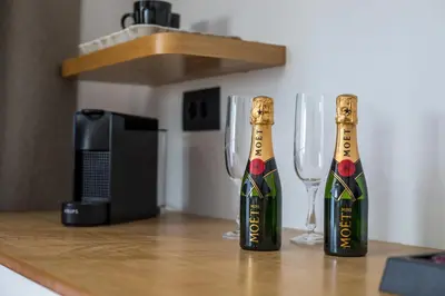 two champagne bottles and two wine glasses on a counter at 3K Rodo Rooms in Faliraki