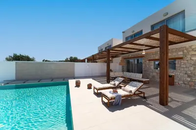 a patio with a swimming pool and a house at Luna Llena Villas in Afantou