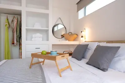 a bedroom with a bed with a mirror and a table at Luna Llena Villas in Afantou