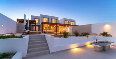 an exterior view of a house with stairs and lights at Luna Llena Villas in Afantou