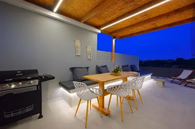 a kitchen with a table and chairs and a stove at ArmoniKon Pool Villas in Asgourou