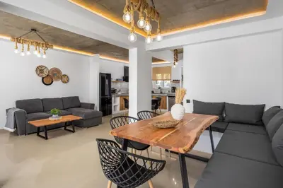 a living room with a table and a couch at ArmoniKon Pool Villas in Asgourou