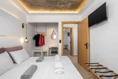 a bedroom with a bed and a tv on the ceiling at ArmoniKon Pool Villas in Asgourou