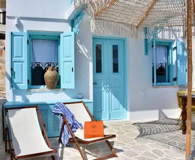 a house with blue doors and a chair at SALT RETREAT - Seafront Villa in Halki
