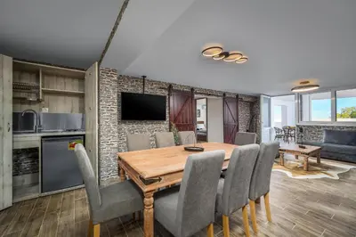 a kitchen and dining room with a wooden table and chairs at Psychedelia Beach House in Gennadi