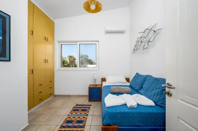 a living room with a blue couch and a window at Psychedelia Beach House in Gennadi