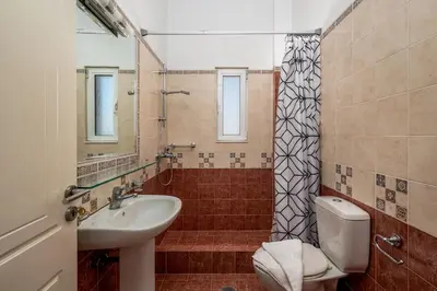 a bathroom with a sink and a toilet and a shower at Psychedelia Beach House in Gennadi