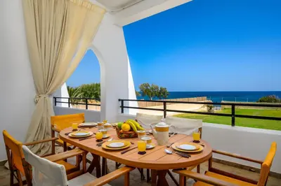 a dining room with a table and a view of the ocean at Psychedelia Beach House in Gennadi
