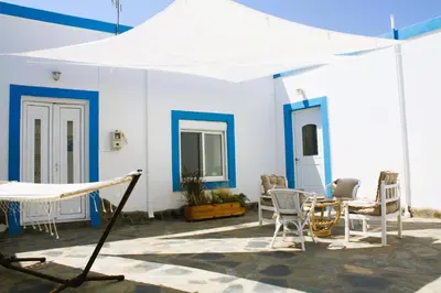 a patio with a white tent and chairs and a table at Villa FLORA in Kattavía