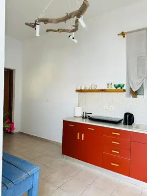 a kitchen with red cabinets and a counter top at Villa FLORA in Kattavía