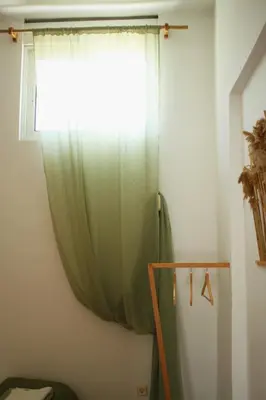 a green curtain in a room with a window at Villa FLORA in Kattavía
