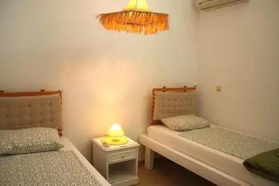 a bedroom with two beds and a lamp on a table at Villa FLORA in Kattavía