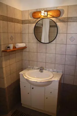 a bathroom with a sink and a mirror at Villa FLORA in Kattavía