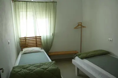 a bedroom with two beds and a window at Villa FLORA in Kattavía